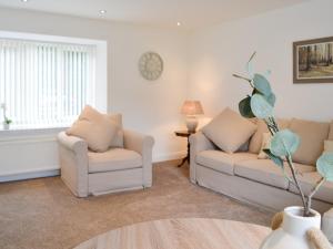 a living room with two couches and a table at Kirroughtree Steading 2 - Uk42904 in Newton Stewart