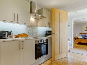 a kitchen with white cabinets and an open door at 2 bed in Stanton-by-Bridge 87408 in Chellaston
