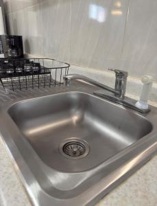 Un fregadero de acero inoxidable con grifo en una cocina. en Bellísimo departamento, lo vas a disfrutar!, en Monterrey 34 fotos más