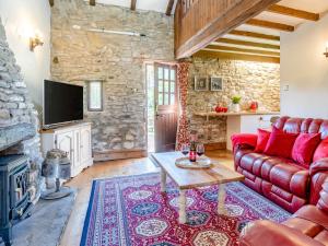 a living room with a red couch and a fireplace at 1 bed property in Gower 77981 in Penclawdd