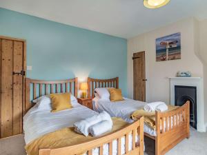 two twin beds in a room with a fireplace at 2 Bed in Bacton 86430 in Bacton