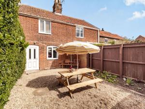 a picnic table with an umbrella in a backyard at 2 Bed in Bacton 86430 in Bacton +9 photos