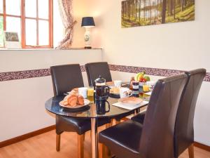 einen Tisch mit Stühlen und einen Tisch mit Essen drauf in der Unterkunft 2 Bed in Godshill IC078 in Godshill + 5 Fotos