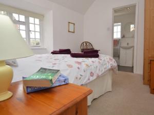 a bedroom with a bed and a table with a lamp at 1 Bed in Burton Bradstock DC178 in Burton Bradstock