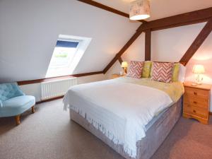 ein Schlafzimmer mit einem großen Bett und einem blauen Stuhl in der Unterkunft 2 Bed in Godshill IC078 in Godshill