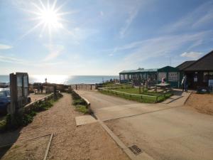 a dirt road next to a beach with the sun at 1 Bed in Burton Bradstock DC178 in Burton Bradstock