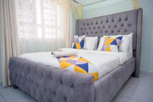a large bed with a large headboard in a bedroom at SpringStone executive apartment A15 in Ongata Rongai 