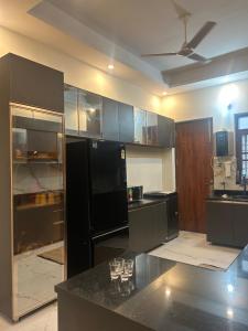 a kitchen with black appliances and a black refrigerator at Shelter and sky in Dehradun +8 photos