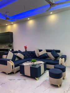 a living room with a blue couch and a table at Shelter and sky in Dehradun