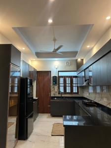 a large kitchen with black cabinets and a ceiling at Shelter and sky in Dehradun
