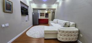 Una sala de estar con un sofá blanco y una silla. en Independence Square Apartment, en Tashkent
