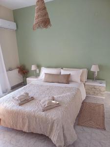 a bedroom with a large bed with two towels on it at Thea Rooftop in Skiathos