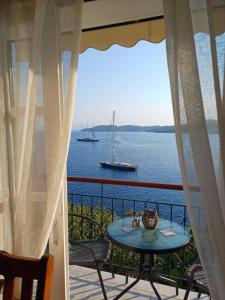 a balcony with a table and a boat in the water at Thea Rooftop in Skiathos