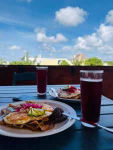 una mesa con dos platos de comida y un vaso de cerveza en Kauil Tulum, en Tulum