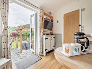 una cucina con un tavolo con tazze sopra e una porta scorrevole in vetro di 1 bed in Patterdale 85532 a Deepdale Altre 11 foto