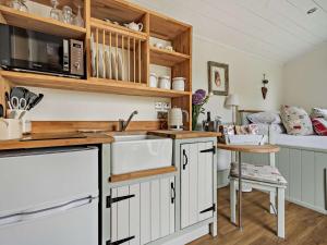 una cucina con mobili bianchi e un lavandino di 1 bed in Patterdale 85532 a Deepdale