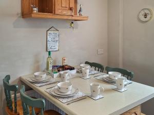 una mesa con tazas y platillos. en The Bee Happy House, en Filey