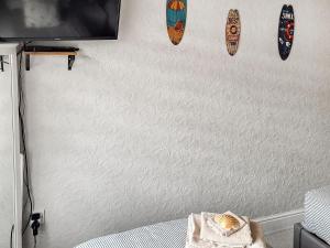 Una habitación con una pared con dos tablas de surf encima. en The Bee Happy House, en Filey
