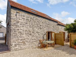 a stone barn with a table in front of it at 2 Bed in Glastonbury 79122 in Glastonbury