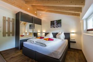 ein Schlafzimmer mit einem großen Bett mit weißer Bettwäsche und roten Kissen in der Unterkunft Haus Sandeck in Ehrwald