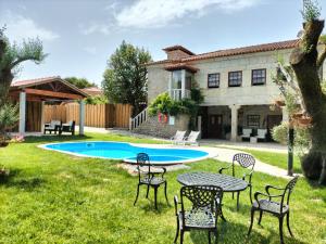a backyard with a table and chairs and a pool at Casas do Rio in Cossourado +45 photos