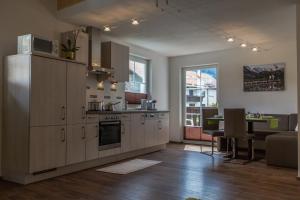 uma cozinha com um frigorífico e uma mesa num quarto em Haus Sandeck em Ehrwald