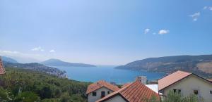 a view of a lake with houses and mountains at Apartman Moj Mir in Igalo +6 photos