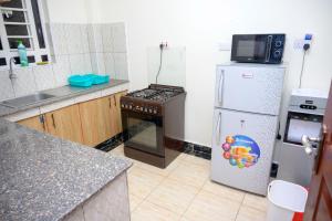 a kitchen with a stove and a refrigerator at SpringStone executive apartment A4 in Ongata Rongai 