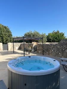a jacuzzi tub in a patio with a table at Agriturismo Masseria sul Mare in Avola