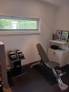 a room with a gym with a chair and a window at Gavi place to stay in Hamburg
