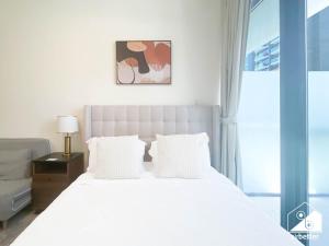 a white bed with white pillows in a bedroom at Urban Charm Studio with Balcony in Azizi Riviera in Dubai +19 photos