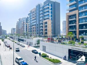 a street with cars parked in a city with tall buildings at Urban Charm Studio with Balcony in Azizi Riviera in Dubai