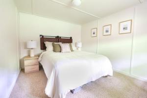 een witte slaapkamer met een groot bed en een spiegel bij Wilderness West Resort Cabin 6 in Colville