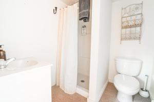 een witte badkamer met een toilet en een wastafel bij Wilderness West Resort Cabin 6 in Colville +13 foto's