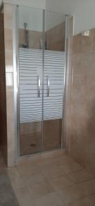 a shower with a glass door in a bathroom at Casa al lago in Lido Di Fondi