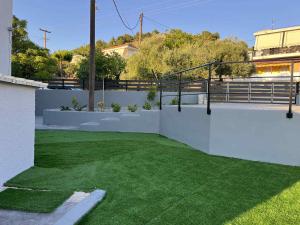 a backyard with green grass and a white fence at Mimis Villa in Igoumenitsa