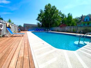 a swimming pool with a wooden deck and a swimming poolvisor at The Laurel Leaf at Annes Windy Poplars in Cavendish +7 photos