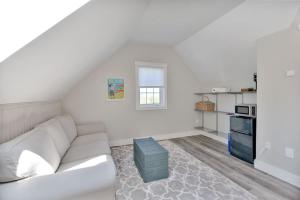 a white living room with a couch and a kitchen at The Euphrates in Cavendish