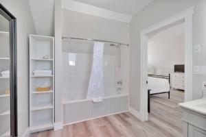 a white bathroom with a shower and a bed at The Euphrates in Cavendish +6 photos