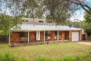 ein altes Backsteinhaus mit einer weißen Garage in der Unterkunft Karri Birdsong Retreat in Margaret River Town