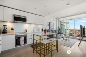 a kitchen and living room with a table and chairs at Executive Suite on the 31st Floor Queen Bed with Sofa Bed Free Parking BBQ in Calgary
