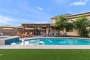 a swimming pool in front of a house at Dream And Drift Luxe Pool Spa Pool Table Firepit Paradise in Casa Grande
