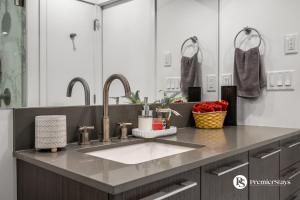 a bathroom counter with a sink and two mirrors at Luxury Spacious 2 Bedroom Apartment at The Radius in Calgary +39 photos