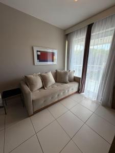 Una sala de estar con un sofá y una ventana grande. en Zeus Residence, en Río de Janeiro