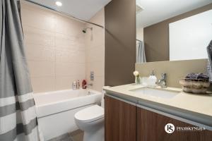 a bathroom with a sink and a toilet and a tub at 28th Floor High Rise Apartment Near Stampede Sleeps 4 with Free Secure Parking in Calgary +18 photos