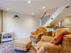 a living room with two chairs and a staircase at 1 Bed in Glastonbury 79123 in Glastonbury