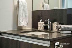 a bathroom counter with a sink and a mirror at 35th Floor High Rise 1 Bedroom with Sofa Bed Apartment at The Guardian South in Calgary +14 photos