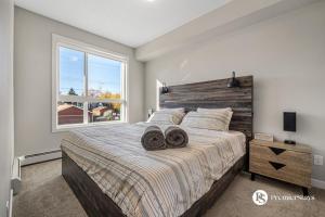 ein Schlafzimmer mit einem großen Bett mit zwei Handtüchern darauf in der Unterkunft Luxury Getaway in Inglewood with 2 Bedrooms Sofa Bed and Heated Underground Parking in Calgary