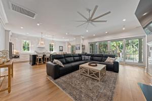 a living room with a black couch and a table at 3290 Coon Hollow in Seabrook Island +57 photos