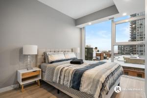 a bedroom with a bed and a large window at Central Downtown near Rogers Sleeps 6 with Two Queen Beds and Parking in Edmonton